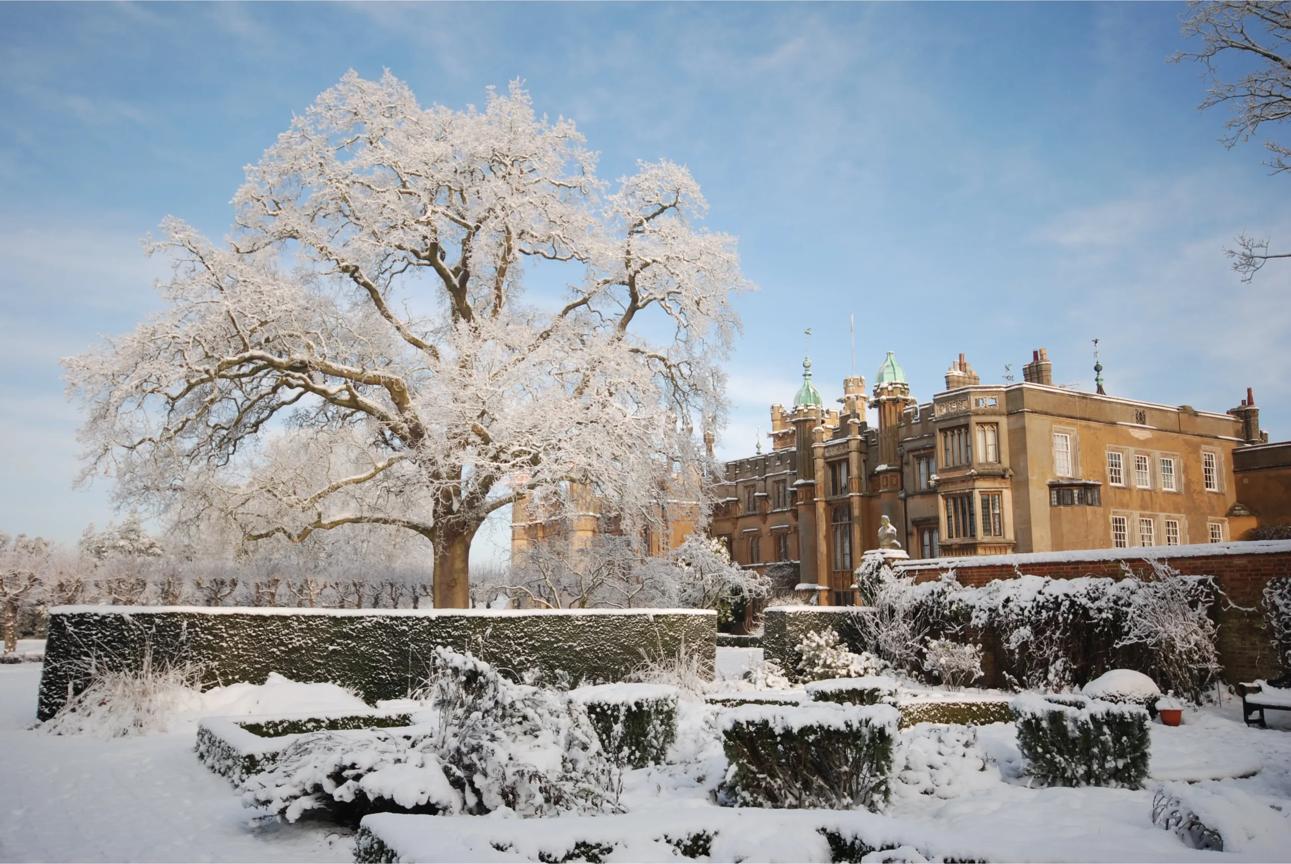 A crisp and snowy day at Knebworth House with fluffy white snow covering the formal gardens.